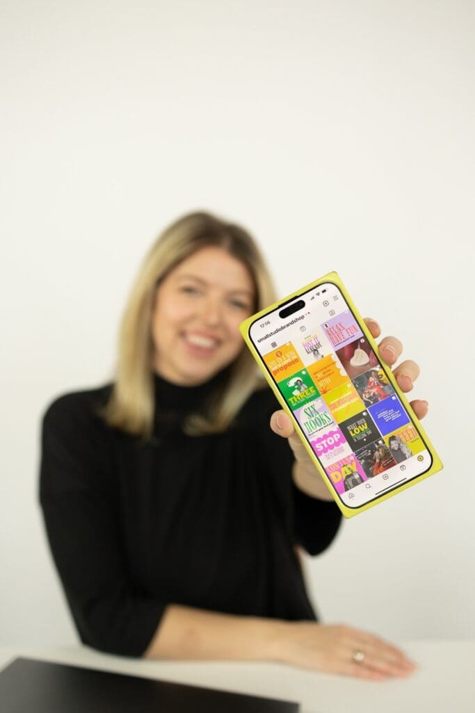 woman holding smartphone with social media feed